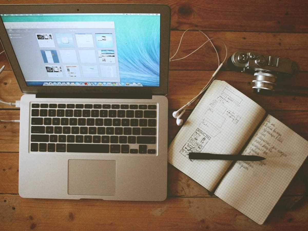 Placeholder photograph of a laptop and notebook on a desk.